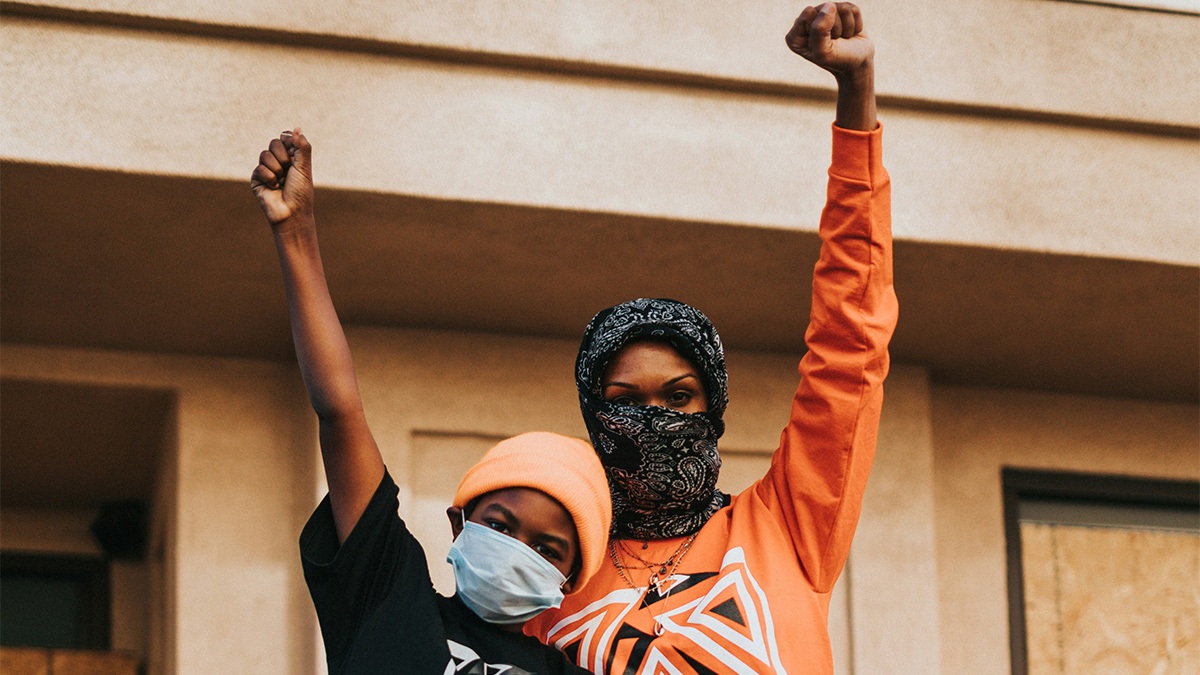 Photograph of two women with their fist raised